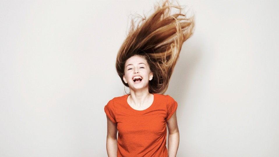 Chica riendo con el pelo al viento