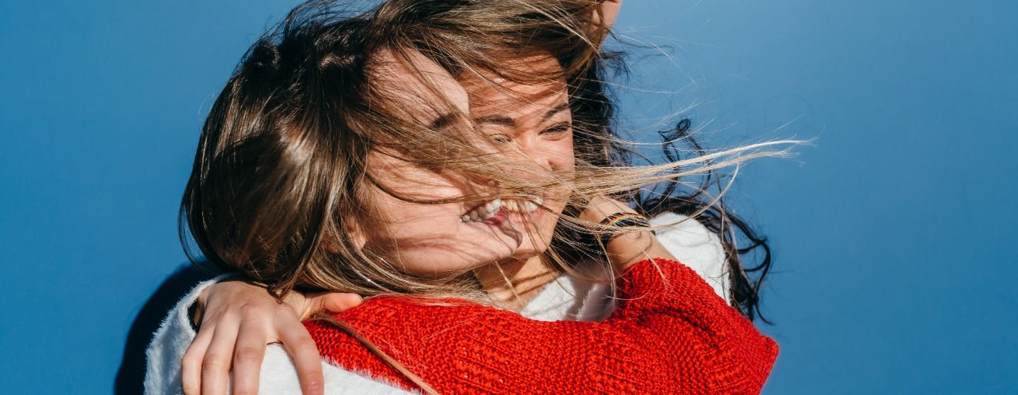 Dos chicas sonrientes abrazadas