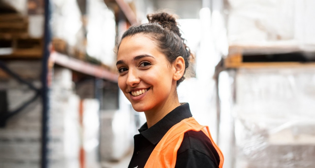 Mujer posa sonriente en un almacén