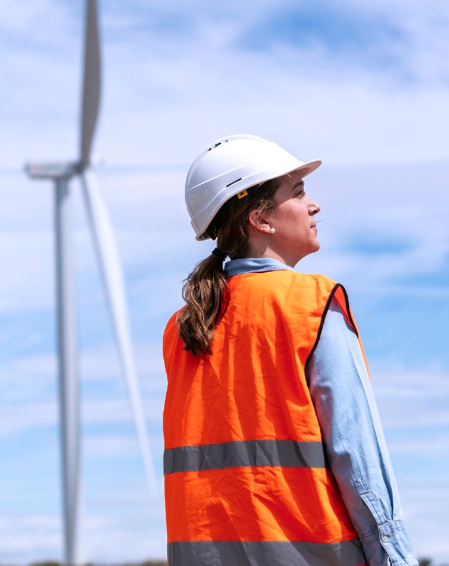 Proyecto Delta, mujer con aerogeneradores de fondo