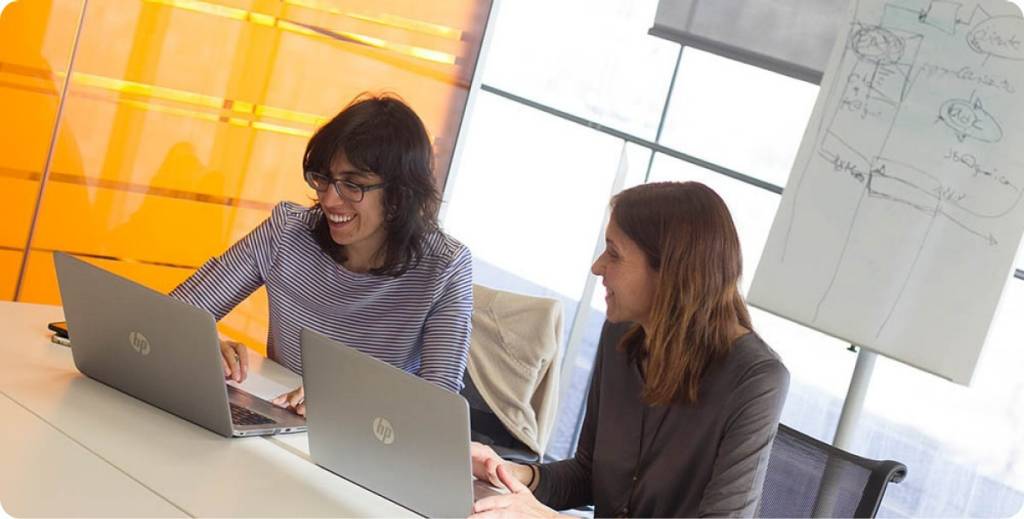 Dos chicas trabajan en equipo con sus ordenadores