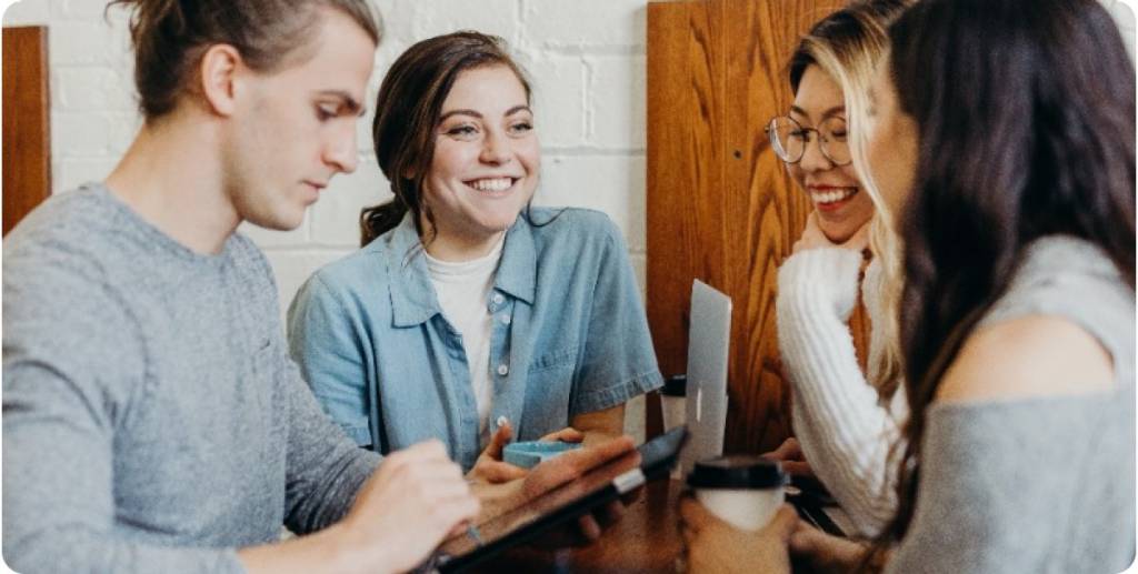 grupo de jóvenes charlando mientras toman café