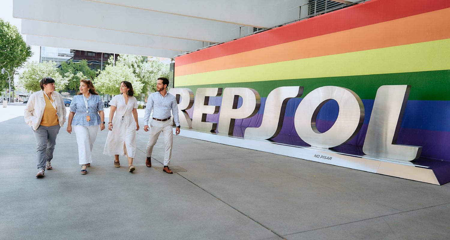 Group of employees at the Repsol Campus entrance with the LGBTQI+ Pride flag