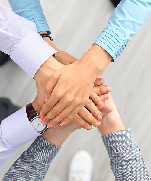 A group of people stacking hands as a sign of commitment