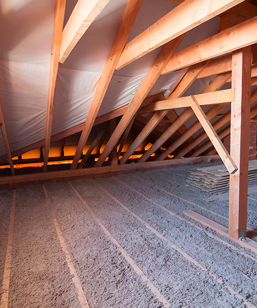 The interior of the walls and floor of an attic, filled with insulating materials