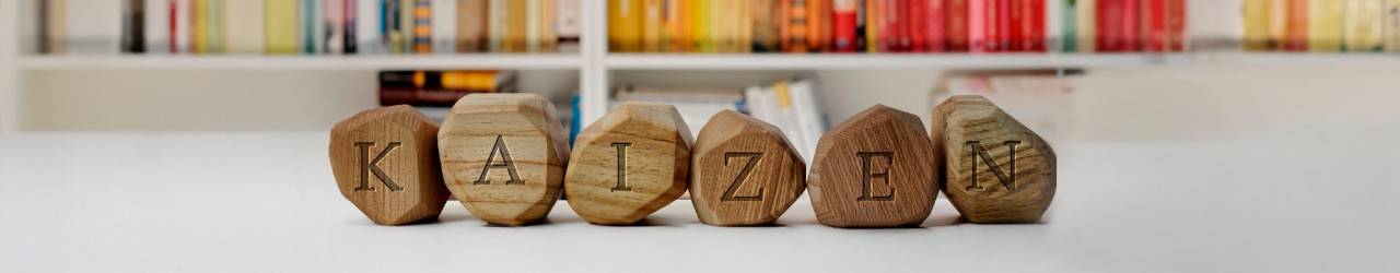 Wooden blocks with a letter forming the word KAIZEN