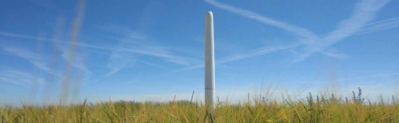bladeless wind turbine in the middle of a field