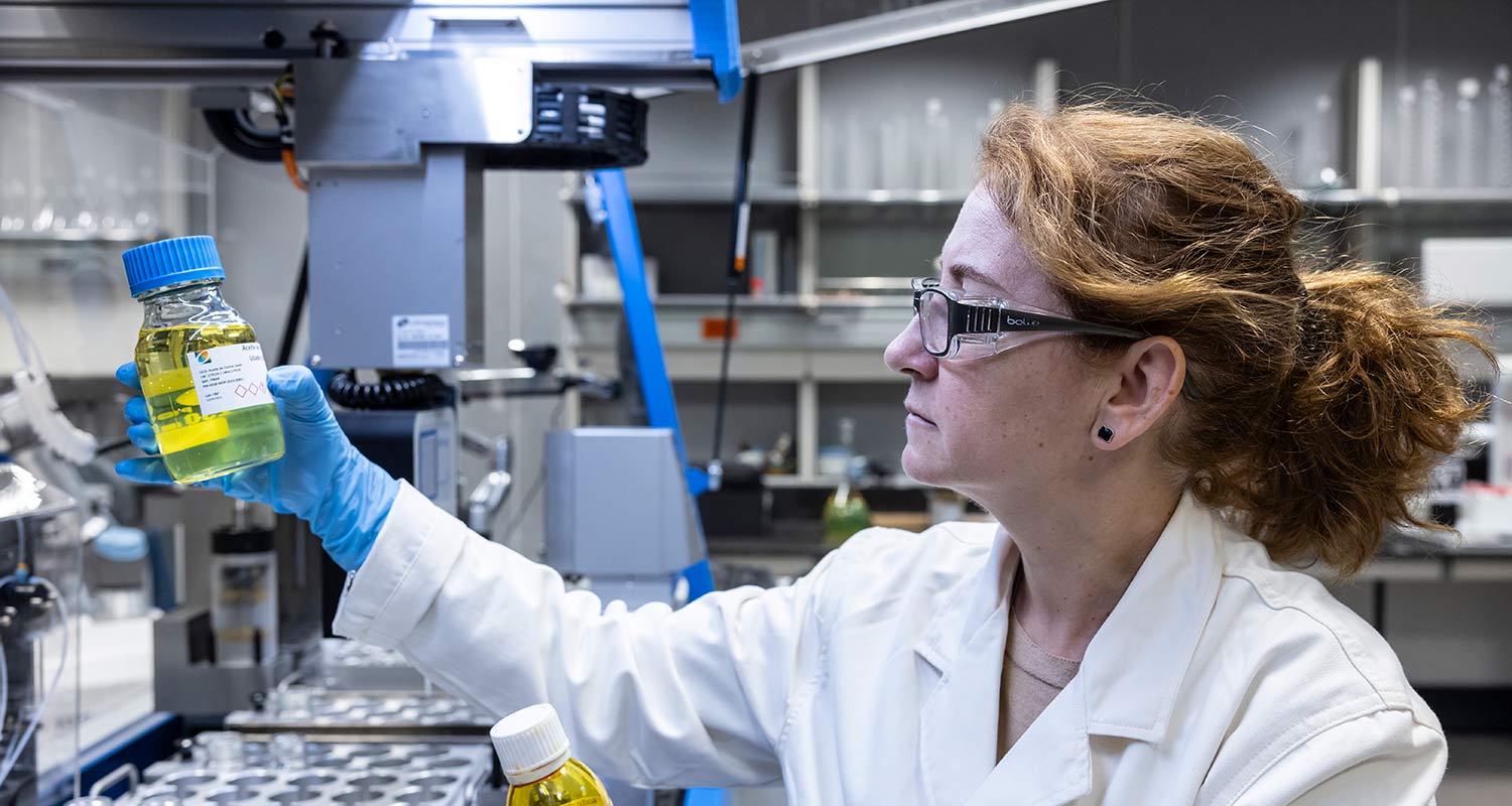 Científica con bata, gafas protectoras y guantes en el laboratorio de Formulación