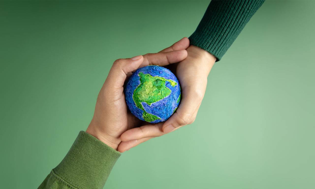 Two interlocking hands holding up a globe
