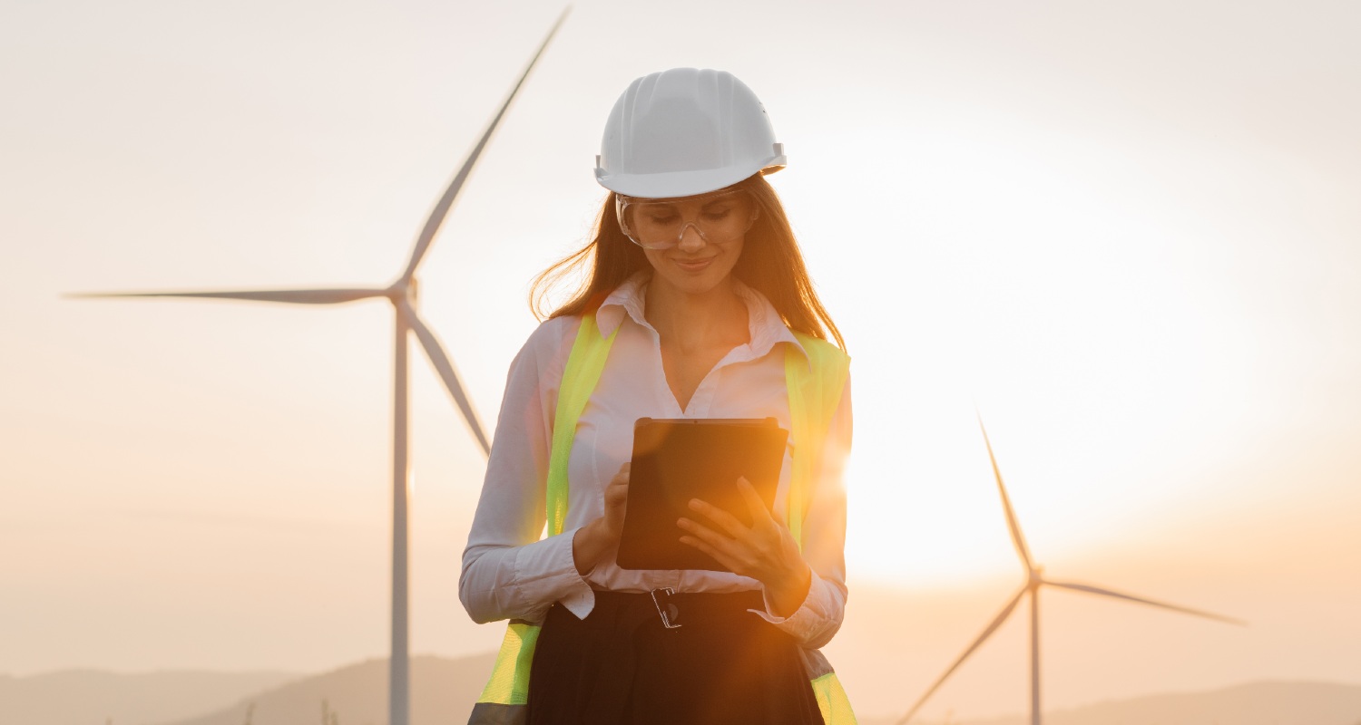Operator using a tablet with wind turbines in the background