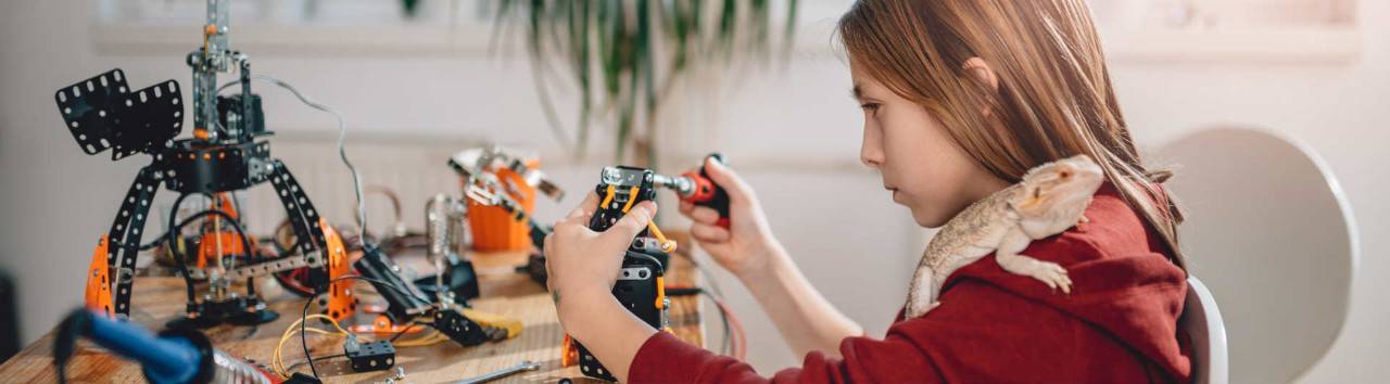 una niña construye un mecano electrónico