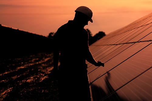 An image of a solar panel maintenance worker