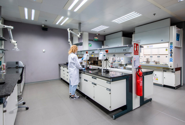 Mujer química con bata blanca en laboratorio