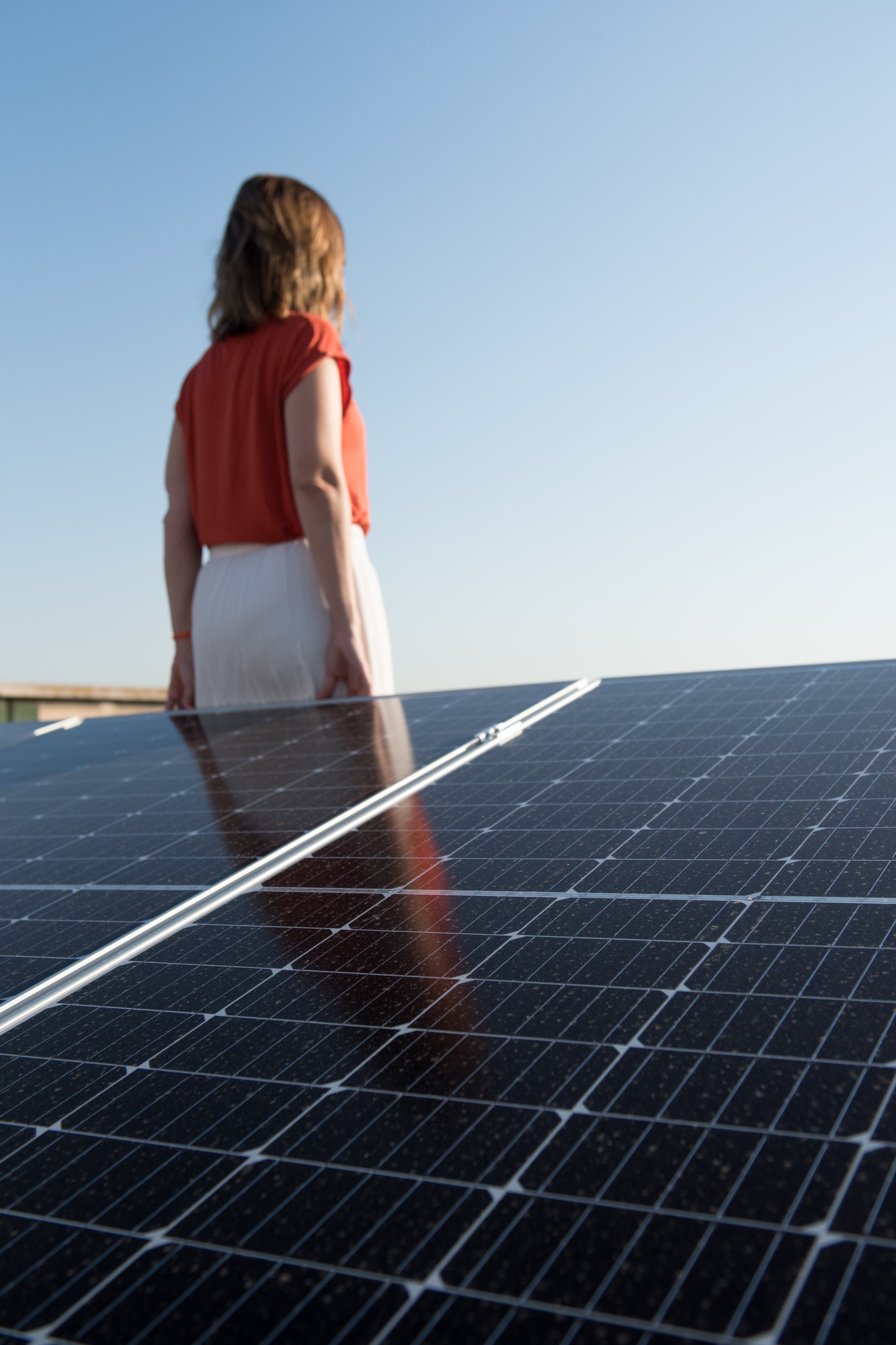 girl standing beside solar panels