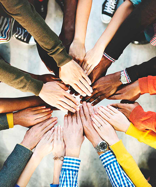  Imagen de un grupo de personas juntando las manos en señal de compromiso
