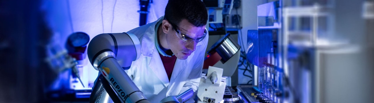 Investigador junto a brazo robótico