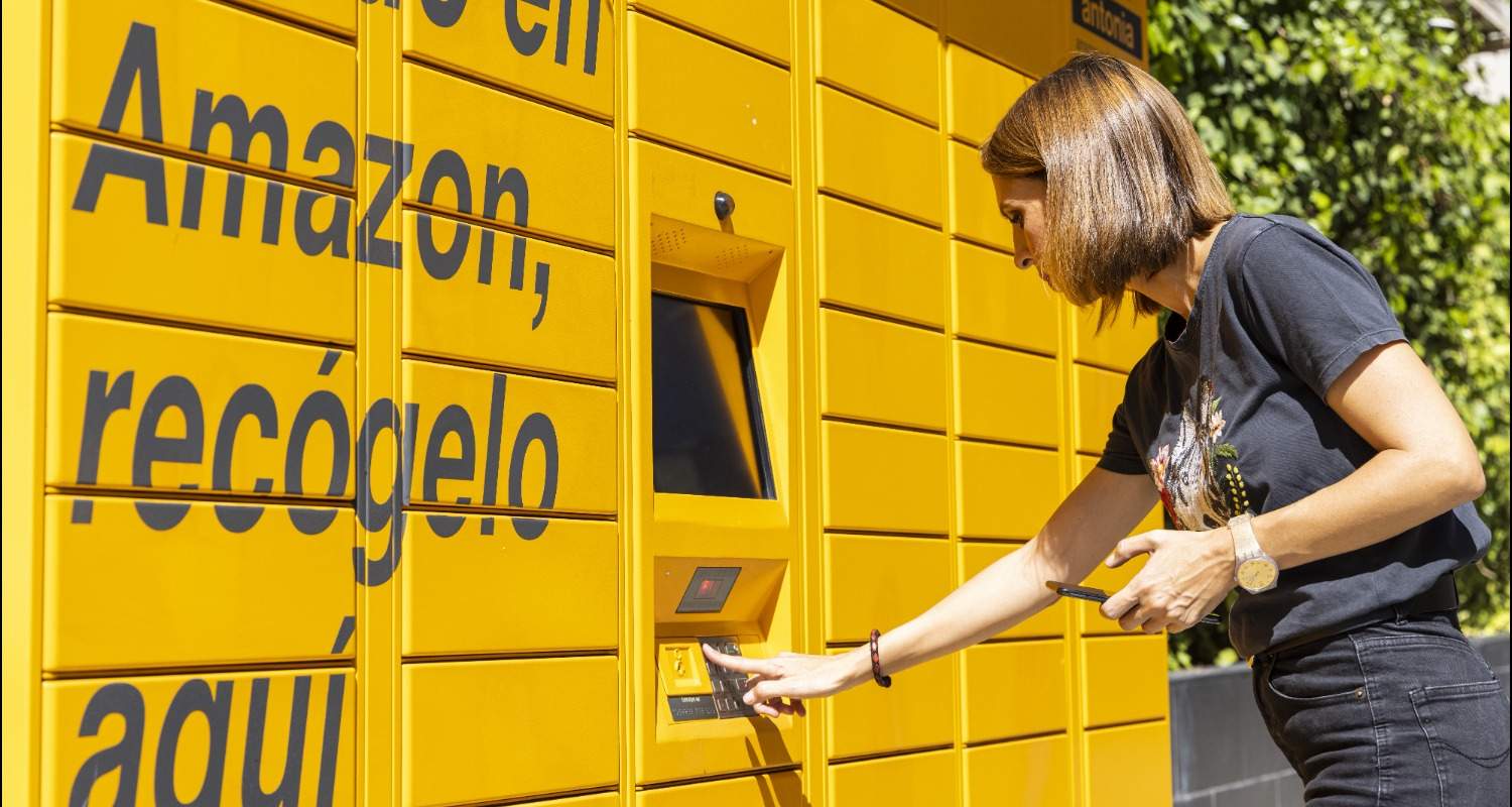 Mujer recogiendo paquete Amazon en un locker en estación de servicio