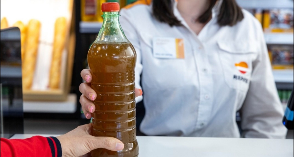Employee collecting a bottle of oil