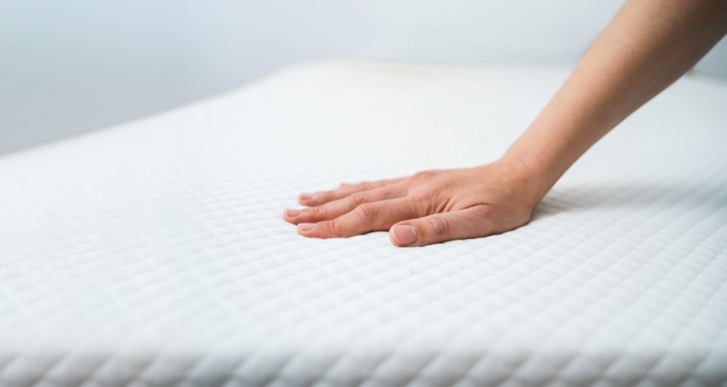 Hand touching a mattress