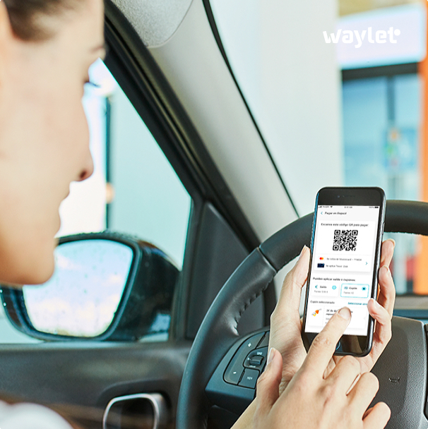 A woman looking at the Waylet app in the car